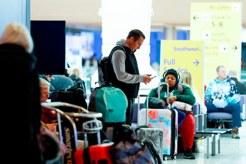 A traveler checks his phone during a winter storm at Denver International Airport on February 22, 2023 in Denver, Colorado. More than 1000 flights have been canceled across the U.S. as the storm impacts travel around the country. (Photo by Michael Ciaglo/Getty Images)