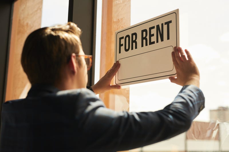 File photo of a real estate agent hanging a "for rent" sign on window of house or apartment