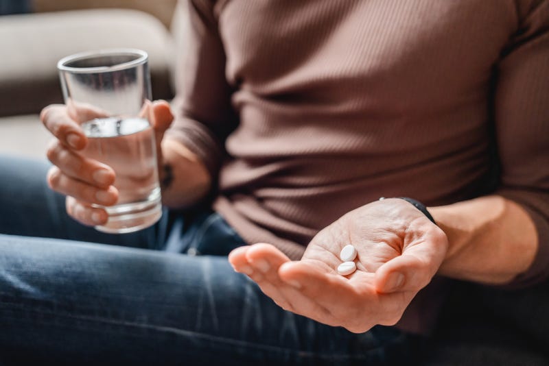 Stock image of man taking aspirin