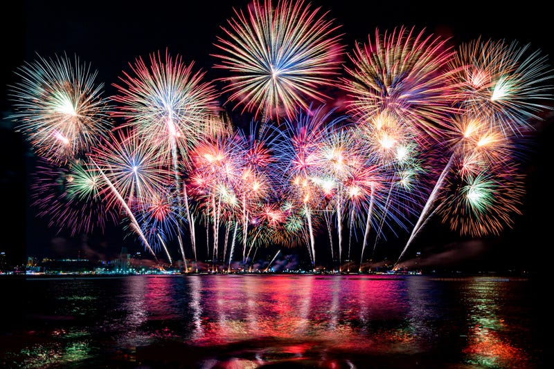 Fireworks light up the sky over a river