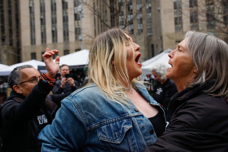 A Trump supporter (L) argues with an anti-Trump protester (R) after she removed an anti-Trump banner outside Manhattan Criminal Court on April 4, 2023