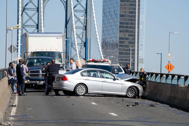 Police investigate near a BMW that crashed on the Manhattan Bridge during a pursuit on April 13, 2023