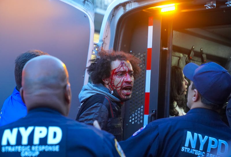 Polis officers take an injured man into custody in SoHo on May 8, 2023