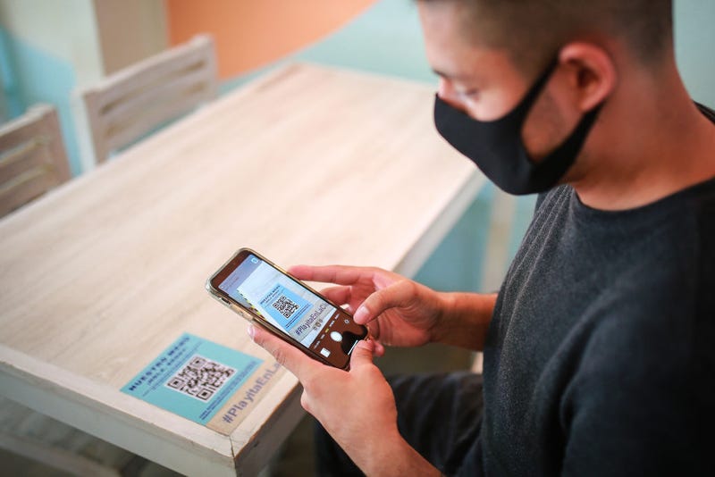 A costumer reads the QR code to display the digital menu at "Mariscos Mariola" restaurant on July 03, 2020 in Mexico City, Mexico.