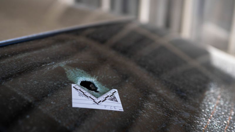 A bullet hole with an evidence marker, which went through a rear window of a car parked across the street where a gunman was shooting at random people on N Dustin Avenue on May 16, 2023 in Farmington, New Mexico. The 18-year-old gunman killed three and injured two police officers and was ultimately shot and killed by responding officers on May 15th. (Photo by Roberto E. Rosales/Getty Images)