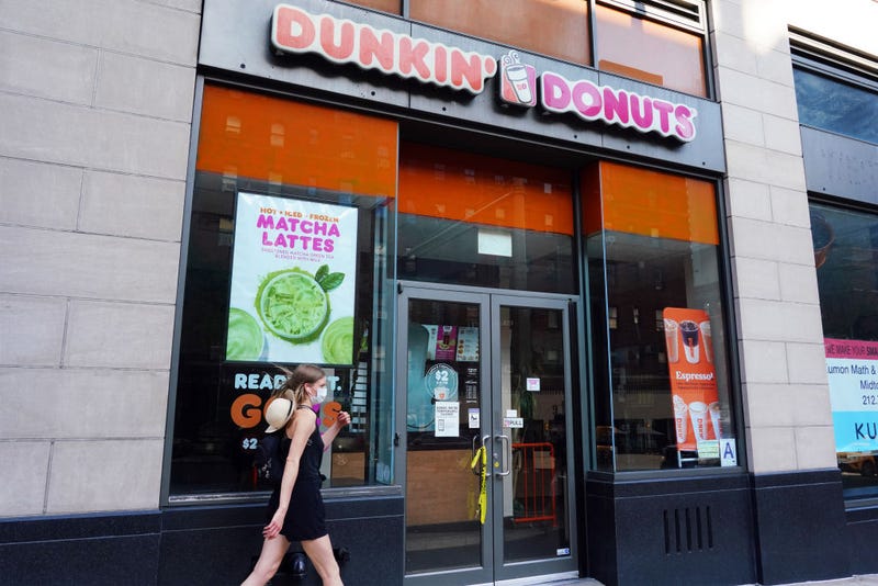 A person in a protective mask walks by a temporarily closed Dunkin' Donuts as New York City moves into Phase 3 of re-opening following restrictions imposed to curb the coronavirus pandemic on July 13, 2020. 