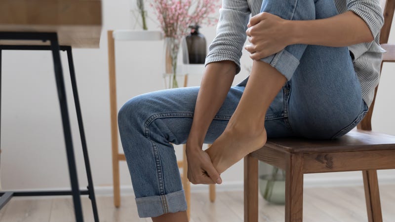 Close up of tired female massage foot suffering from ache