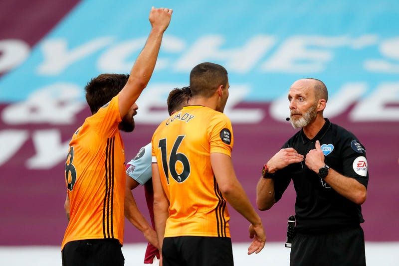 : Conor Coady of Wolverhampton Wanderers reacts towards Mike Dean the match referee during the Premier League match between Burnley FC and Wolverhampton Wanderers at Turf Moor on July 15, 2020 in Burnley, England. Football Stadiums around Europe remain empty due to the Coronavirus Pandemic as Government social distancing laws prohibit fans inside venues resulting in all fixtures being played behind closed doors.