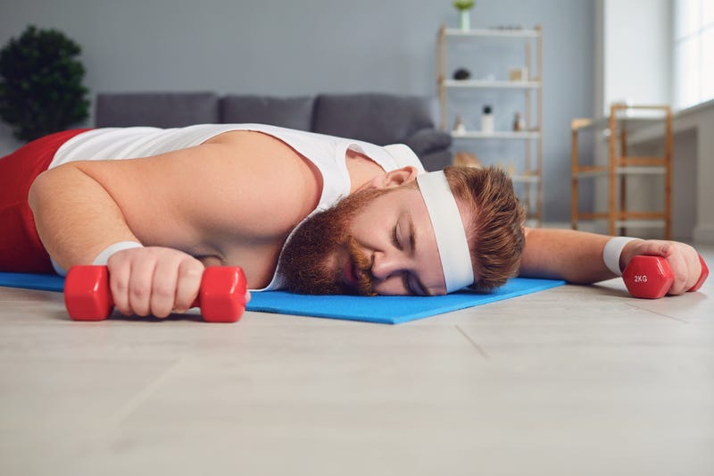 Man asleep with workout equipment stock photo. 