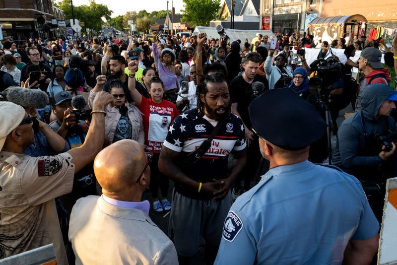 Minneapolis Police Chief Brian O'Hara (L) and former Chief Medaria Arradondo (R) are confronted as they arrive for a vigil at George Floyd Square on May 25, 2023 in Minneapolis, Minnesota. 