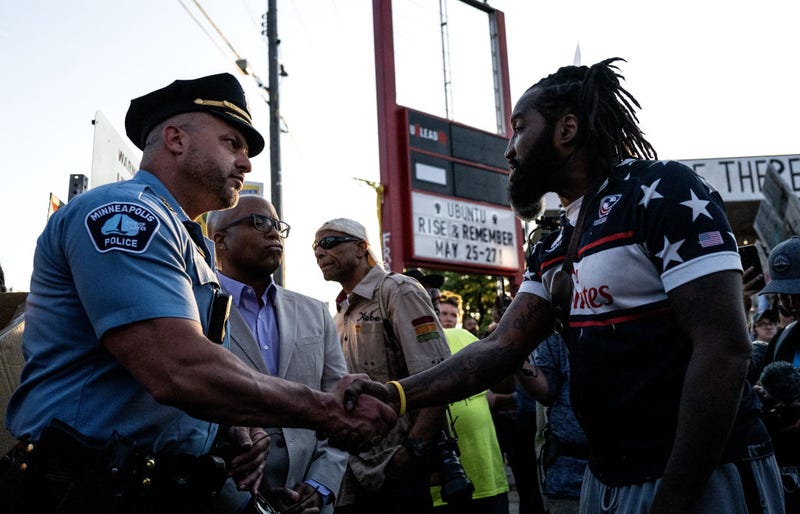 Michael Wilson (R) speaks with Minneapolis Police Chief Brian O'Hara (L) and former Chief Medaria Arradondo (C) as they arrive for a vigil at George Floyd Square on May 25, 2023 in Minneapolis, Minnesota, three years since Floyd was killed in 2020 by a Minneapolis police officer. 