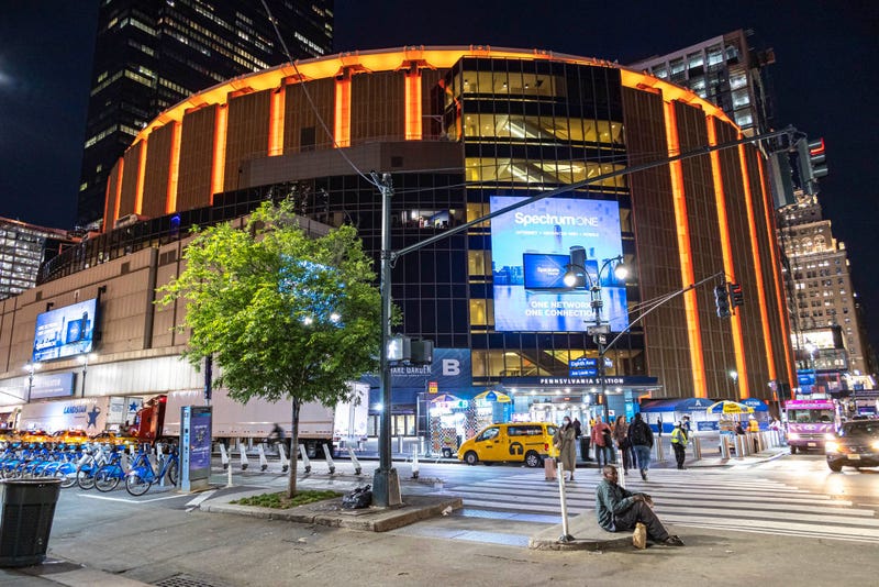 Night street view with illuminated buildings and lights of Madison Square Garden in Manhattan.