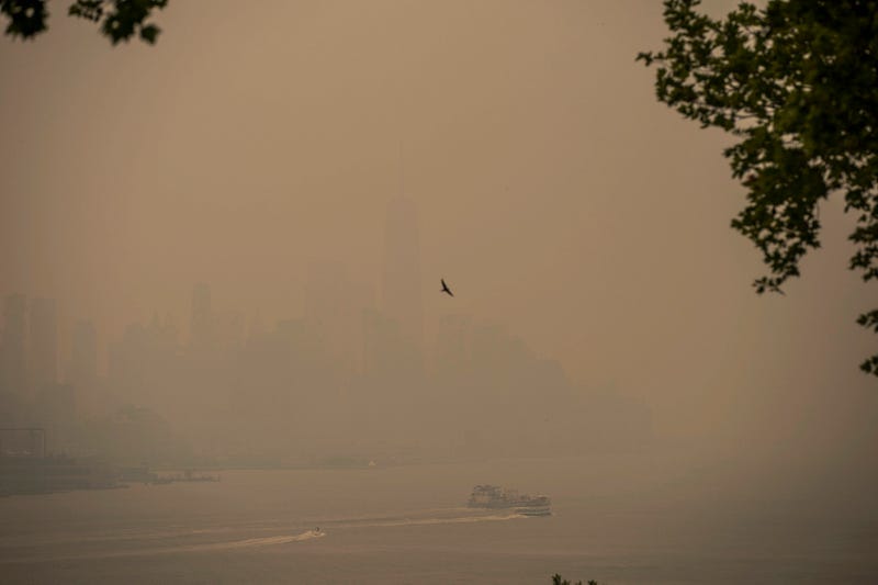 A boat navigates the Hudson River as the New York City skyline is covered with haze and smoke from Canada wildfires on June 7, 2023, in Weehawken, New Jersey