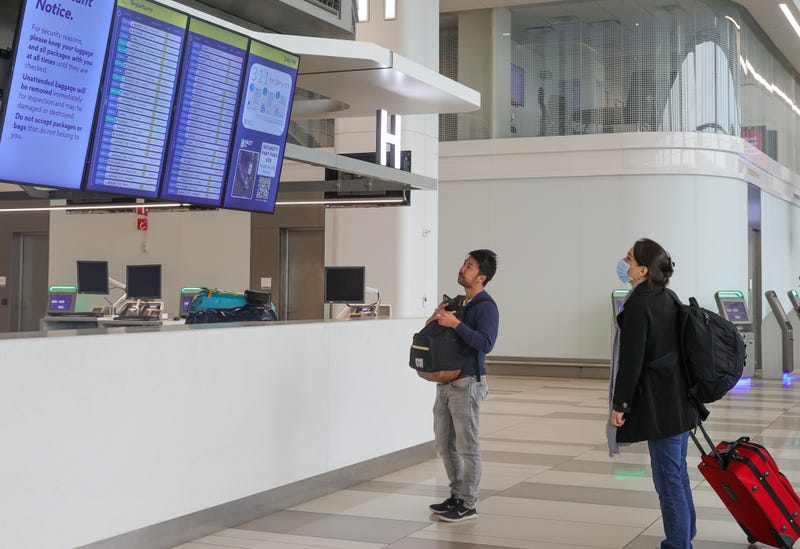 Passengers check an information board after the US Federal Aviation Administration (FAA) warned travelers to expect flights to be delayed at LaGuardia Airport in New York City as smoke from a series of wildfires in Canada limited visibility on June 7, 2023