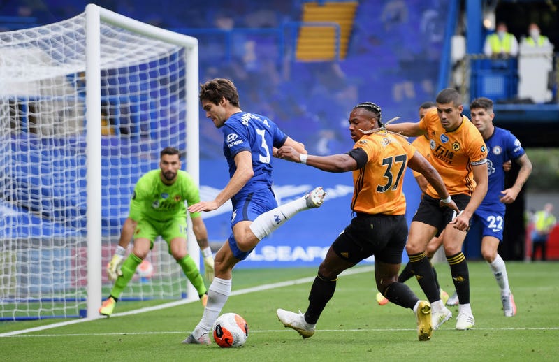 Marcos Alonso of Chelsea battles for possession with Adama Traore of Wolverhampton Wanderers during the Premier League match between Chelsea FC and Wolverhampton Wanderers at Stamford Bridge on July 26, 2020 in London, England. Football Stadiums around Europe remain empty due to the Coronavirus Pandemic as Government social distancing laws prohibit fans inside venues resulting in all fixtures being played behind closed doors.