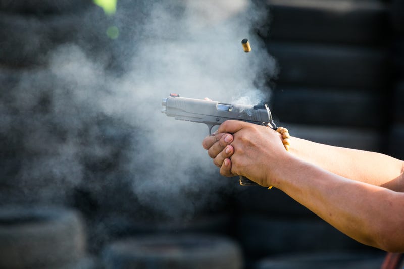 Hands firing a handgun.