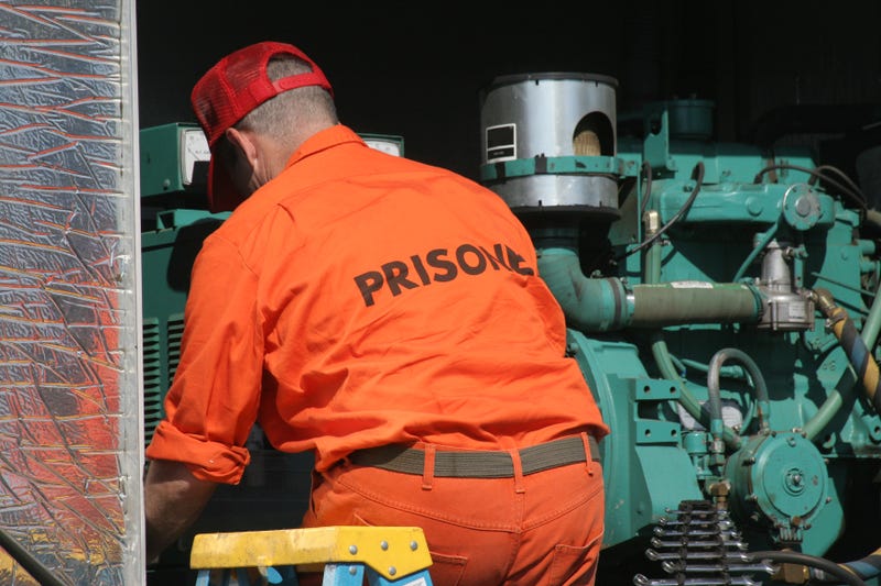 A prisoner works on equipment