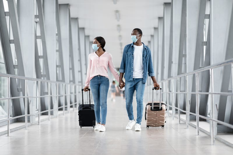 People wearing masks in an airport stock photo.