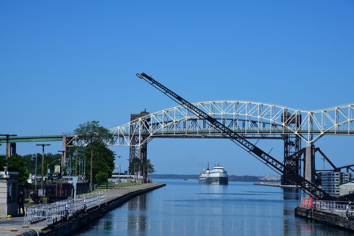 A trade ship approaches the Soo Locks as a gate is raised to let it enter