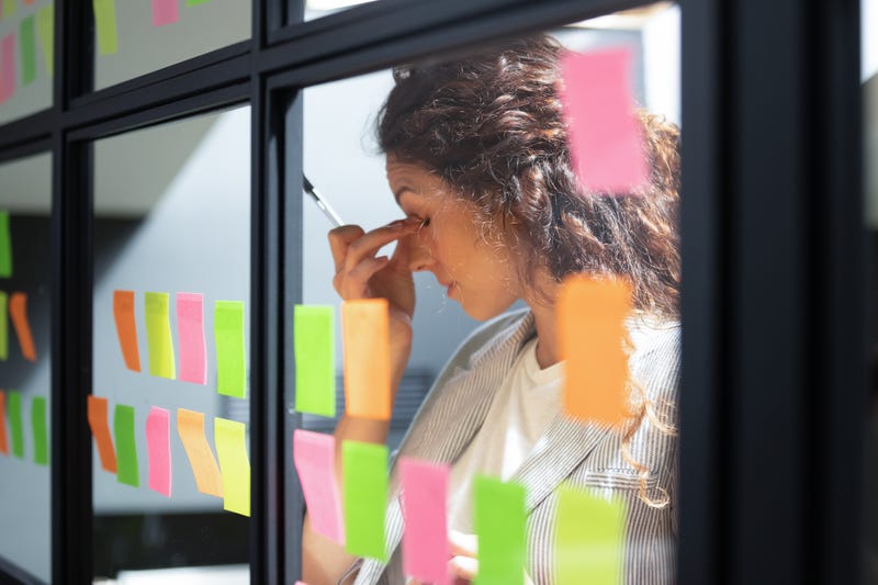 Tired woman touching nose bridge, working with sticky papers 