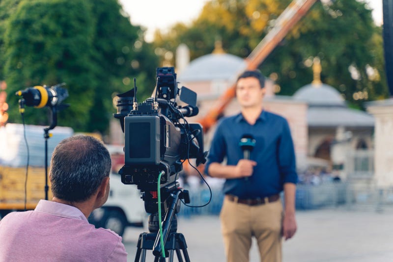 ameraman working on professional camera taking TV interviewer