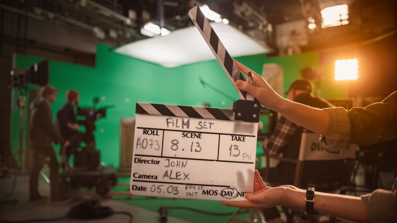 A film set with clapper, camera, director and green screen