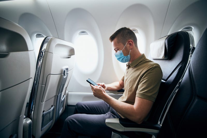 Man wearing face mask inside airplane.