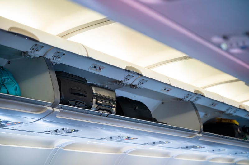 Overhead bin compartment on airplane - stock photo