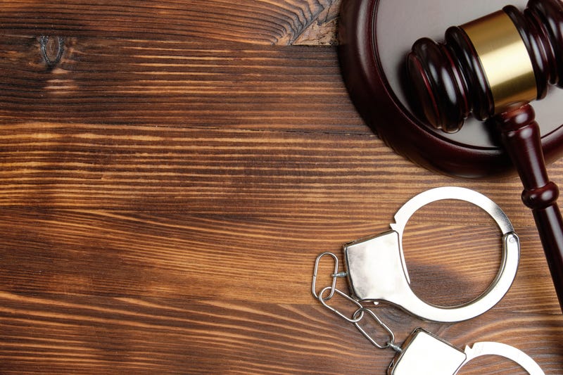 Judge hammer with handcuffs on wooden background with copy space.