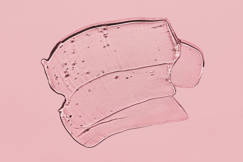 drop of clear liquid serum on pink background