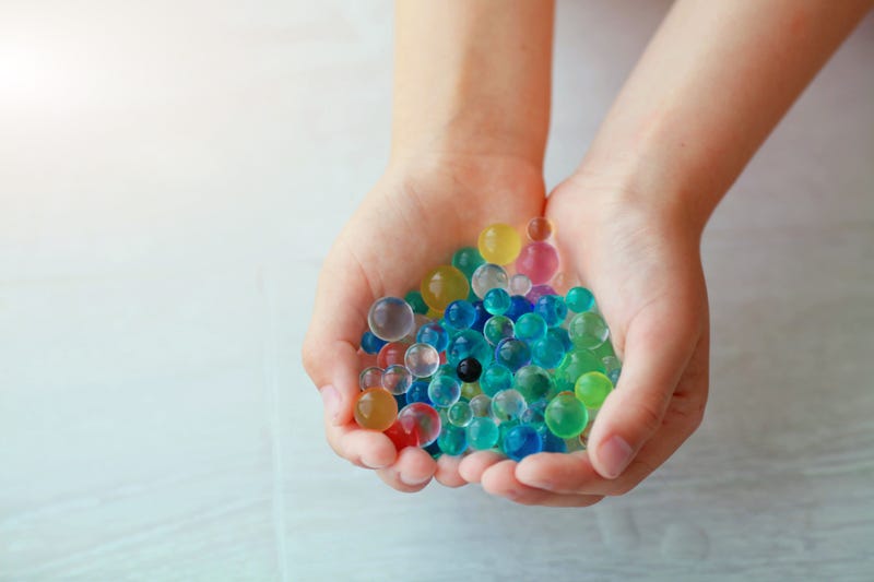 Children is hands are holding the orbeez. Decoration with hydrogel water balls