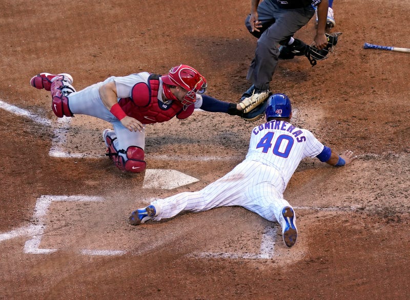 CHICAGO, ILLINOIS - AUGUST 19: Willson Contreras #40 of the Chicago Cubs avoids the tag of Andrew Knizner #7 of the St. Louis Cardinals and scores during the second inning of Game Two of a doubleheader at Wrigley Field on August 19, 2020 in Chicago, Illinois.