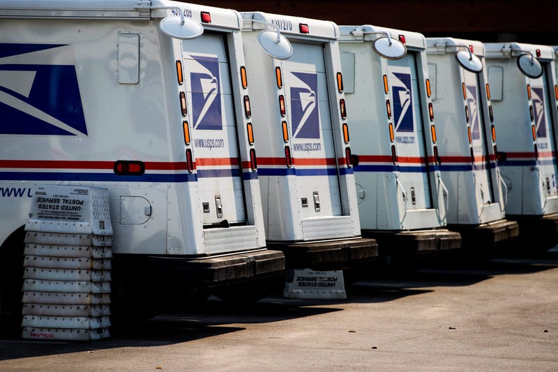 Mail trucks are lined up at a post office
