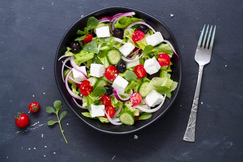 Greek salad with fresh cucumber, tomato, sweet pepper, lettuce, red onion, feta cheese and olives olive oil. Healthy food