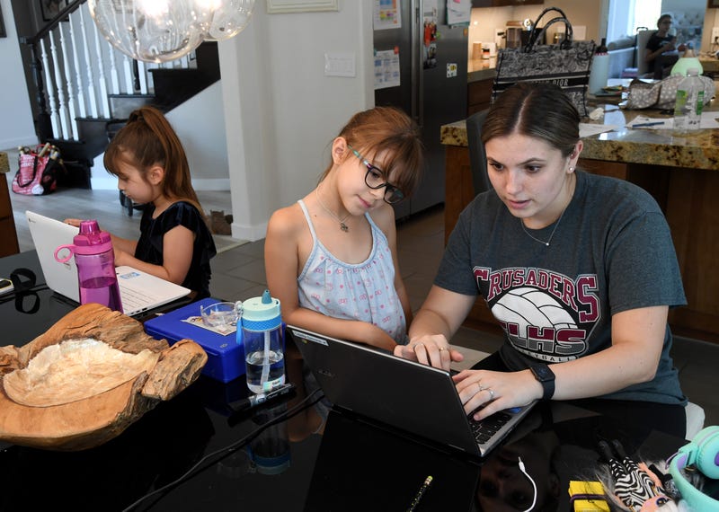 Goolsby Elementary School second grader Ella Dweck, 7, takes an online class as Goolsby Elementary School second grader Odette Conrad, 7, is tutored by College of Southern Nevada student Jordyn Leal