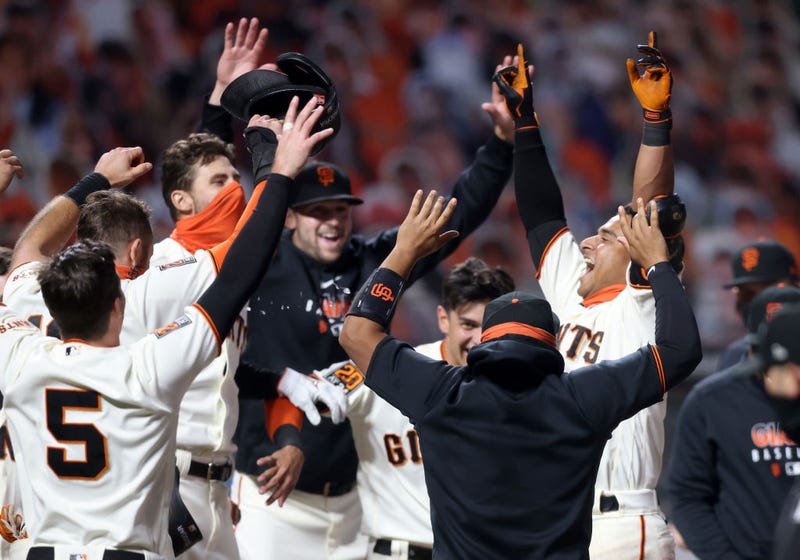 Donovan Solano #7 of the San Francisco Giants is congratulated by teammates after he hit a walk off home run to win the game in the 11th inning against the Los Angeles Dodgers at Oracle Park on August 25, 2020 in San Francisco, California.