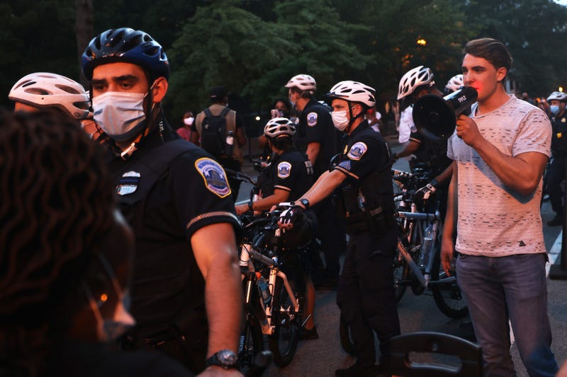 Police officers surround Jacob Wohl as he taunts protesters during a "Trump/Pence Out Now" rally at Black Lives Matter plaza August 27, 2020 in Washington, DC. Protesters gathered as the Republican National Convention on its final night was set to nominate President Donald Trump for a second term in office.