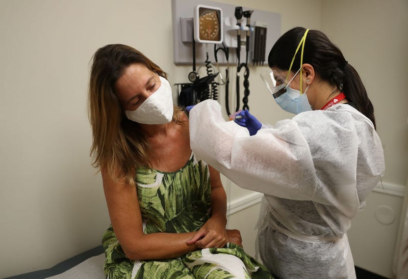Enbal Sabag, a Nurse Practitioner, wears personal protection equipment as she administers a flu vaccination to Noel Janzen at the CVS pharmacy and MinuteClinic on September 03, 2020 in Key Biscayne, Florida.