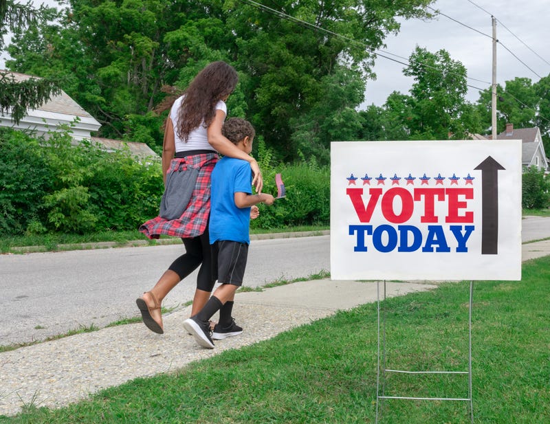 Woman walking with kid to vote
