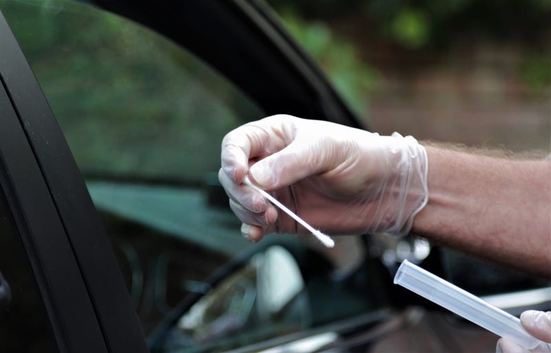Hands of NHS worker at mobile coronavirus testing station
