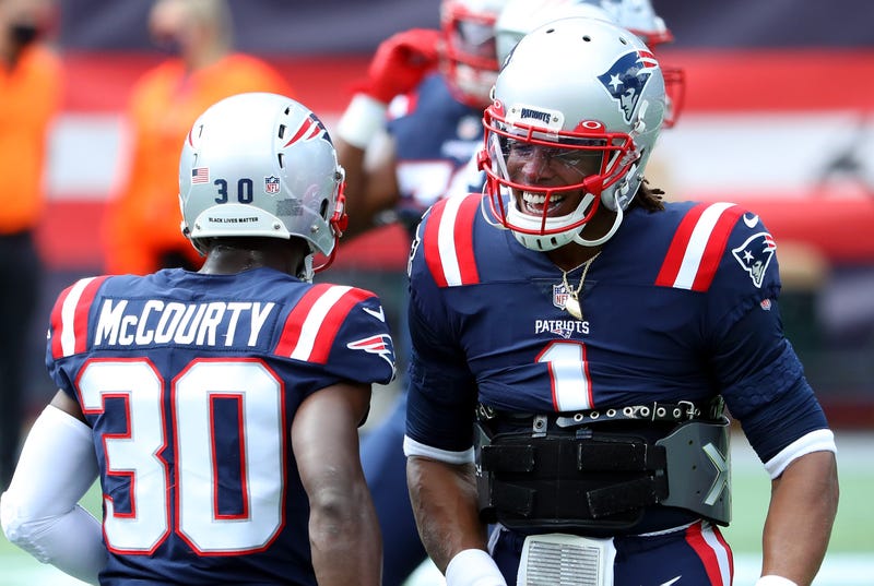 Patriots players Cam Newton and Jason McCourty celebrate during game.