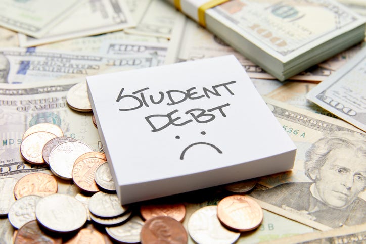 money and a notepad with the words: student loan debt