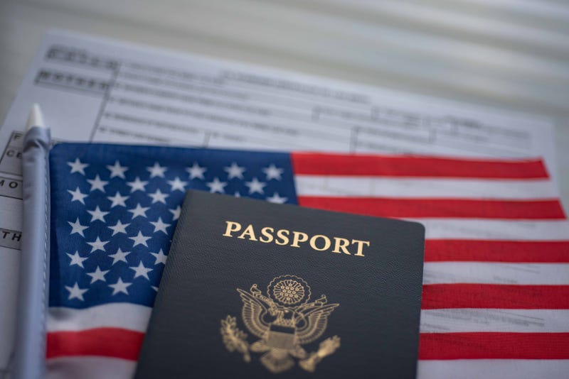 lurred U.S. standard application certificate of live birth application form next to American flag and Passport of USA. Close up view.