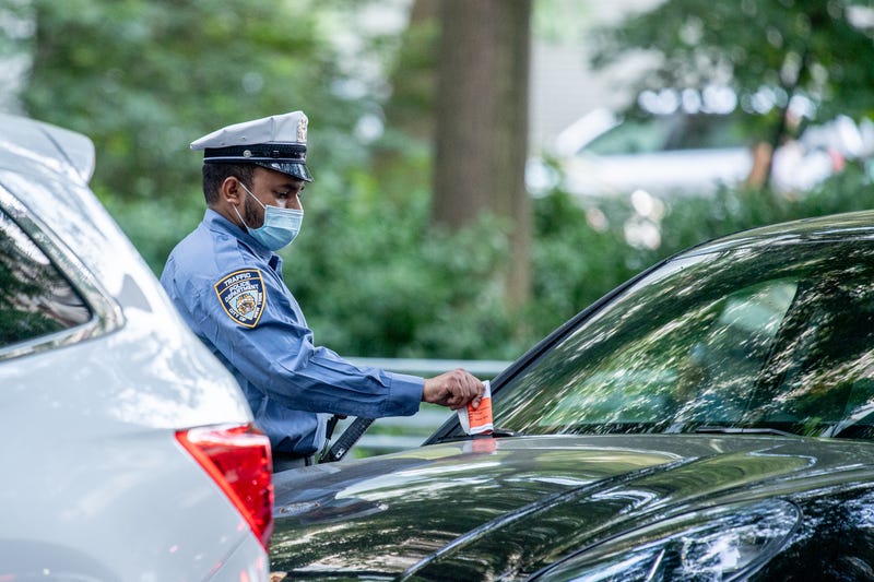 An NYPD parking enforcement issues a ticket near Washington Square Park in Manhattan