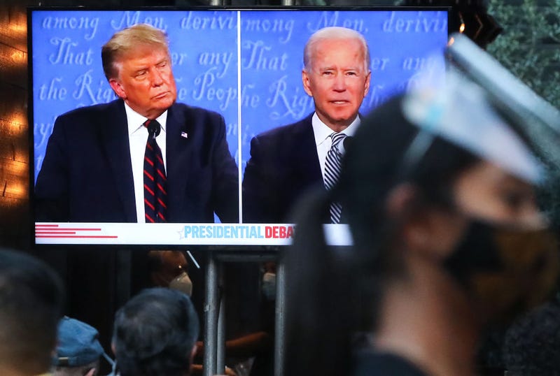 A server wears a face shield and face covering as people sit to watch a broadcast of the first debate between President Donald Trump and Democratic presidential nominee Joe Biden at The Abbey, with socially distanced outdoor seating, on September 29, 2020 in West Hollywood, California. 