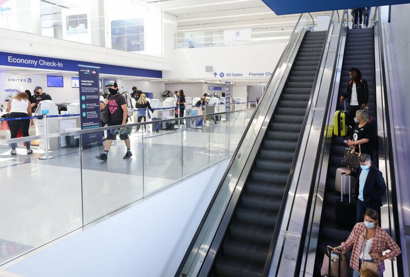 Arriving passengers take an escalator past the check-in area in the United Airlines terminal at LAX.