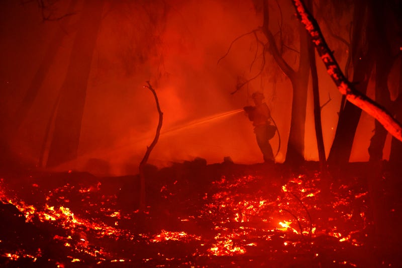 A firefighter sprays water on hot spots while battling the Glass Fire on October 01, 2020 in Calistoga, California.