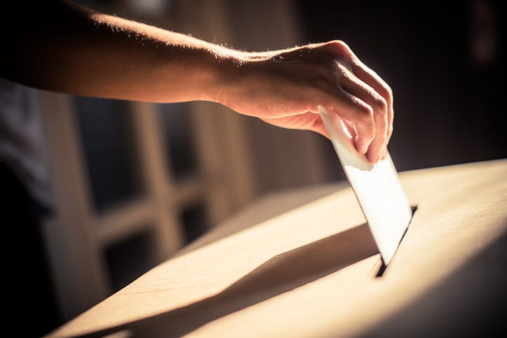 Person casting their ballot. 