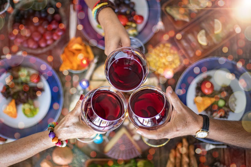 Family dinner for a celebration with red wine and cheers