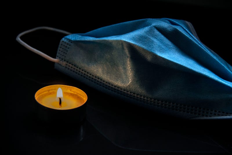 Burning candle and protective medical face mask